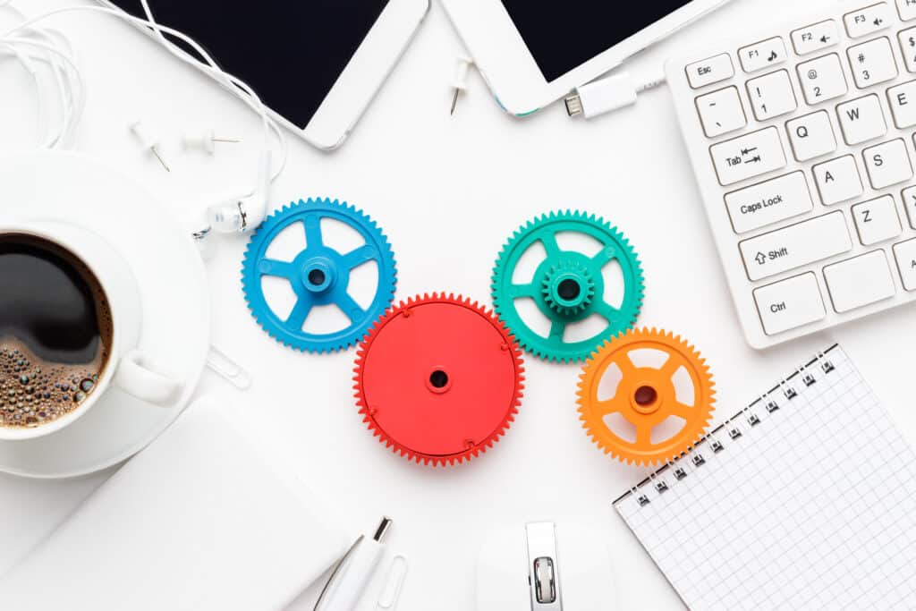 4 cogwheels on a table among office supplies