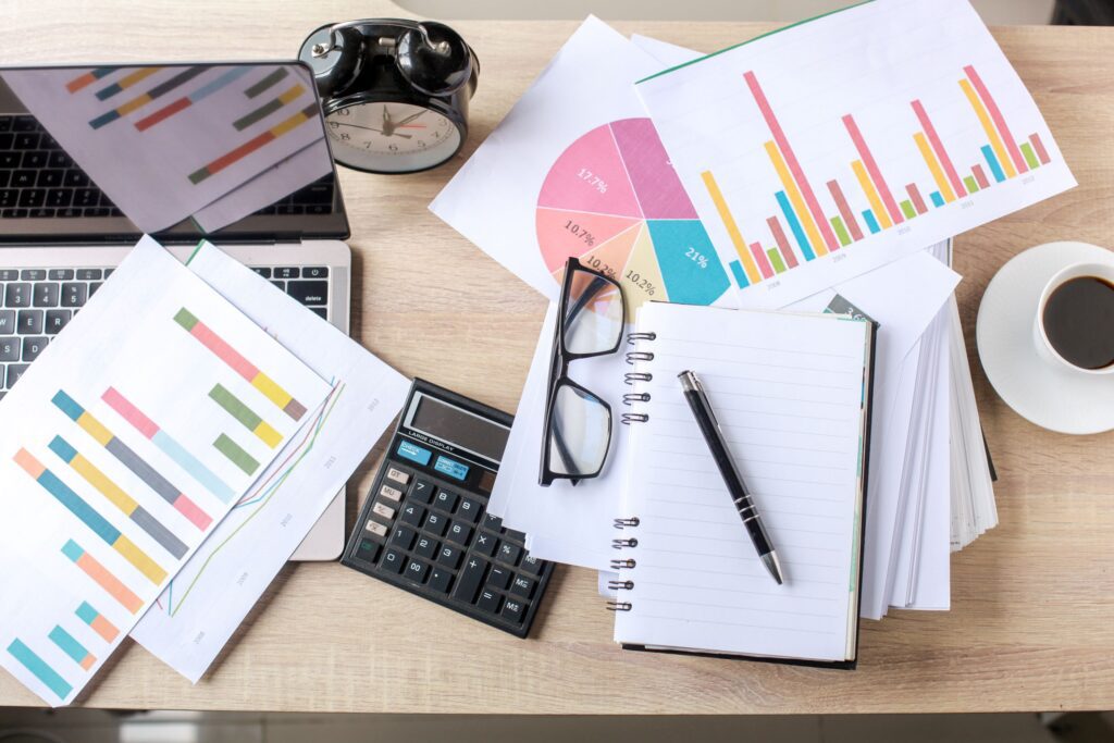 A messy table with graphs and papers scattered all over 